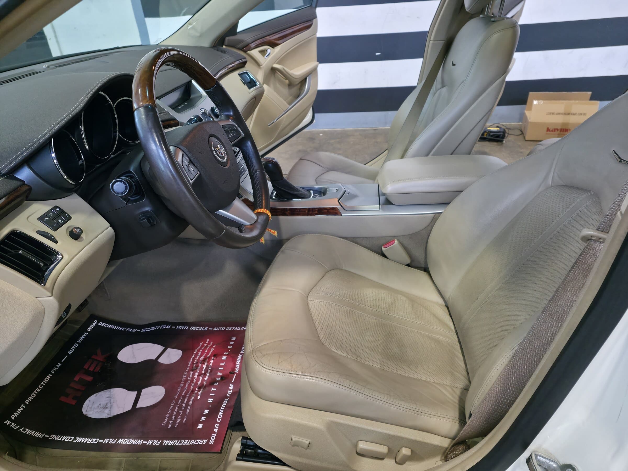 Tan leather front seats, wood trim, and gauge cluster of a Cadillac CTS cleaned and conditioned during an interior steam detail at Mr. G's Auto Care in Westminster, MD