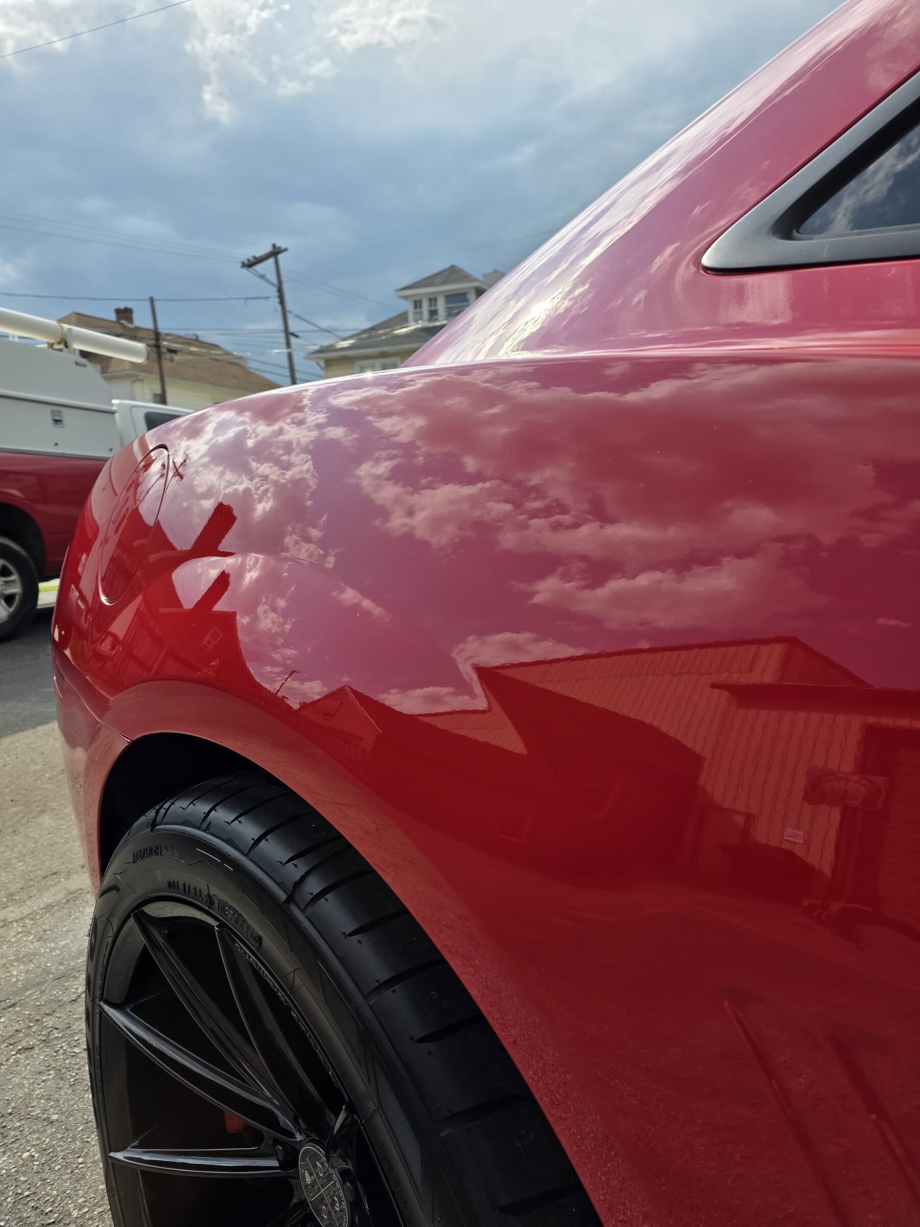 Clouds reflecting in the mirror-flat red paint of a Chevrolet Camaro fender after paint correction in Westminster, MD