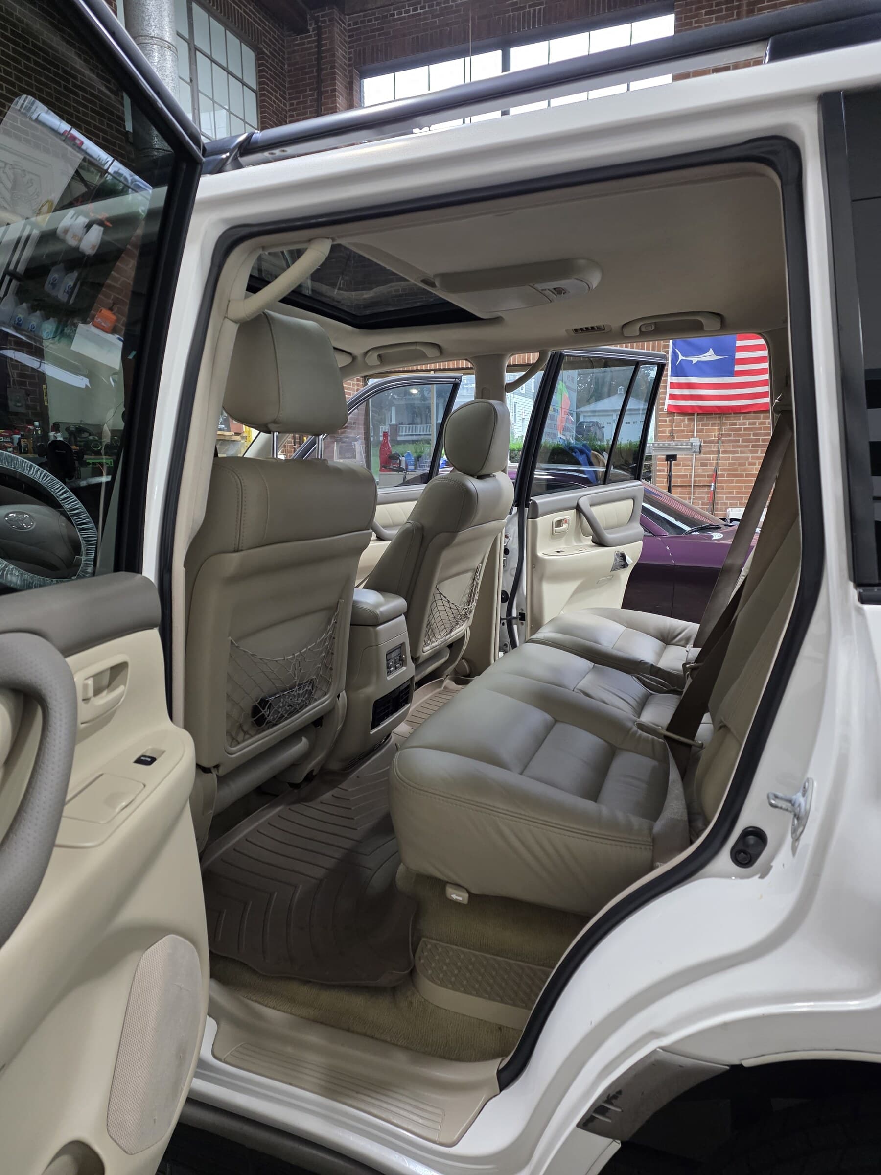 Cleaned and conditioned tan leather interior of a Toyota Land Cruiser after an interior detail at Mr. G's Auto Care in Westminster, MD